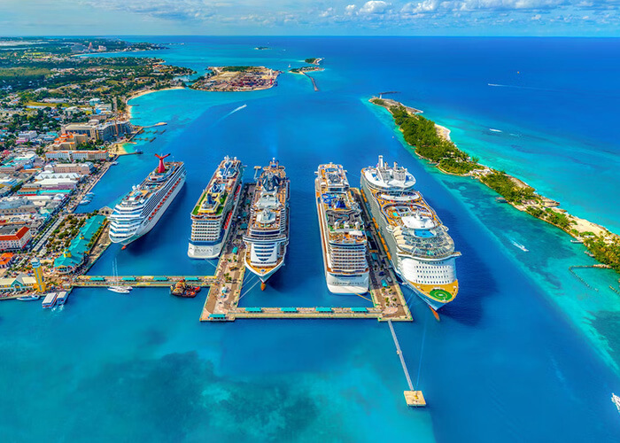 Aerial view of multiple cruise ships docked in a vibrant blue harbor, showcasing luxurious amenities and exotic destinations, ideal for an unforgettable cruise adventure.