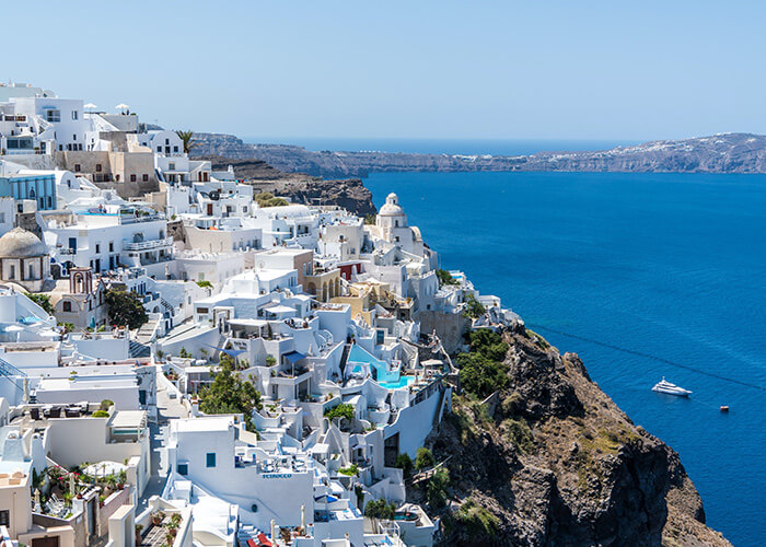 White-washed buildings of Santorini overlooking crystal-clear waters, embodying the stunning landscapes and rich culture of Europe.